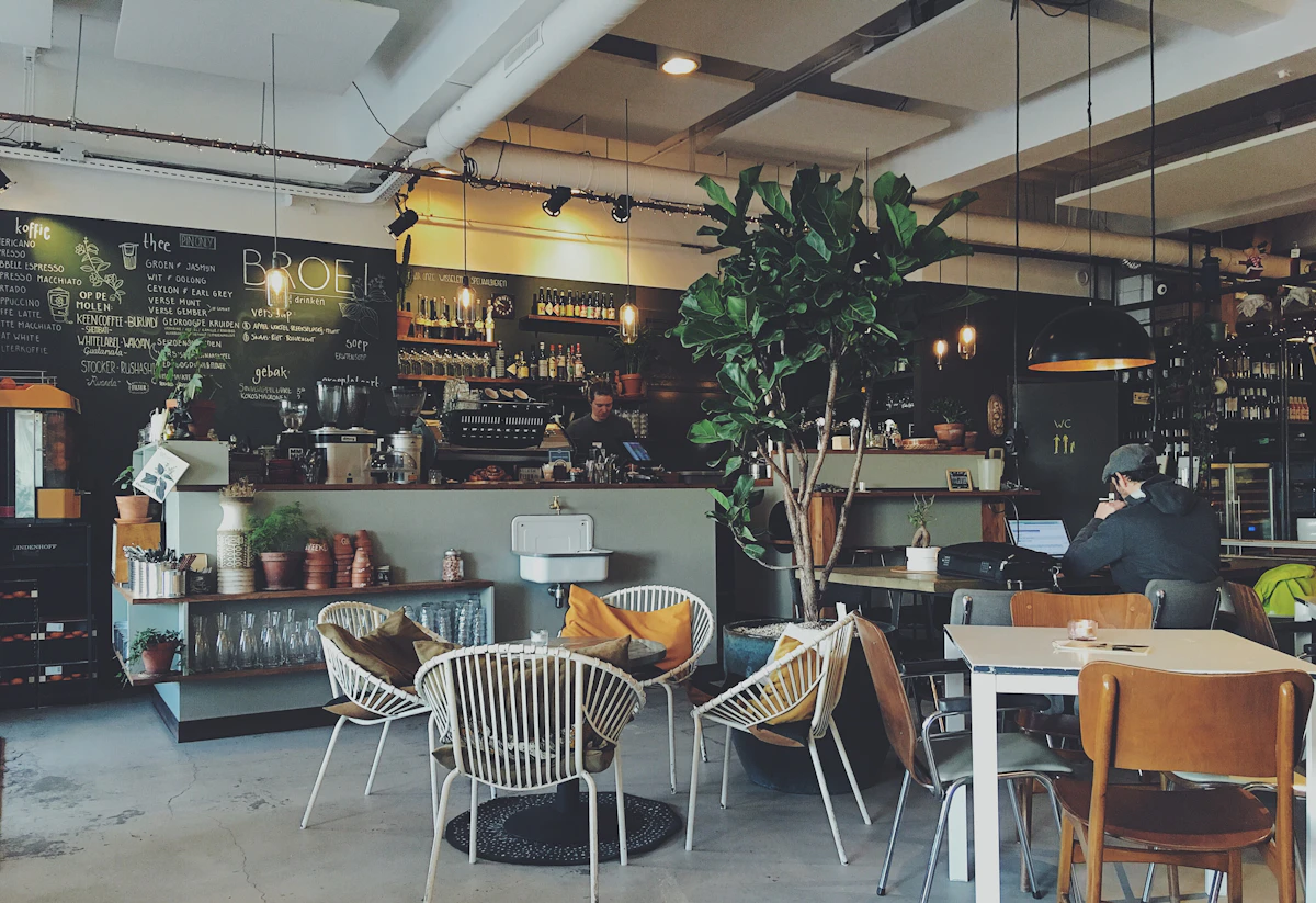 Équipe en discussion dans un café moderne avec une atmosphère professionnelle et rassurante